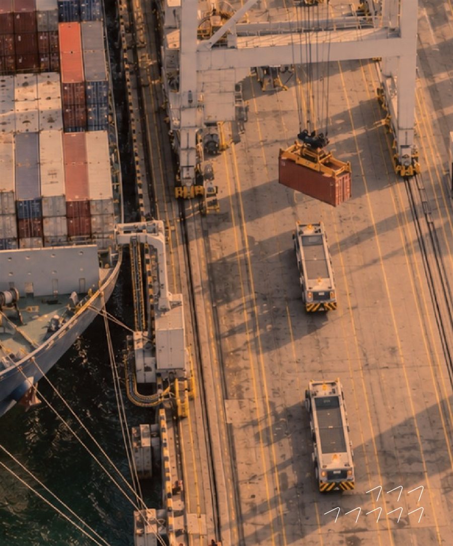 A crane lifting a container at a port beside a cargo ship